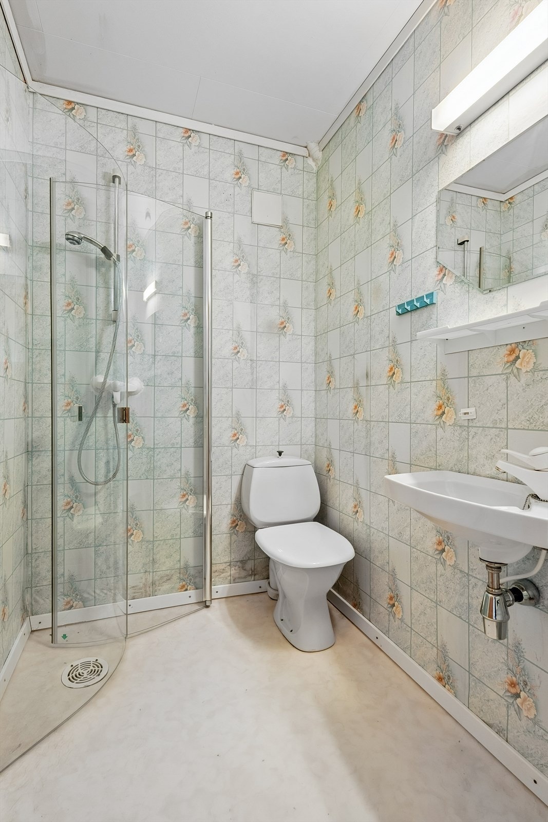 Badet er innreidd med toalett, dusj på vegg med innfellbare dusjveggar og vegghengt servant. Galleribilde