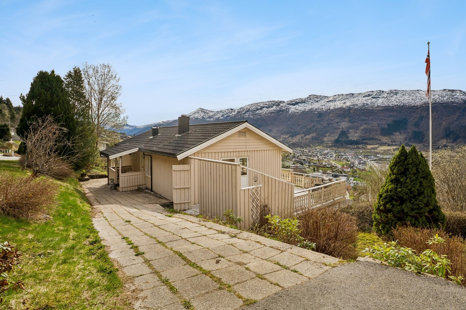 Eit sjarmerande og grønt hageområde med plenareale, terrassse, prydbusker og frukttre. Galleribilde