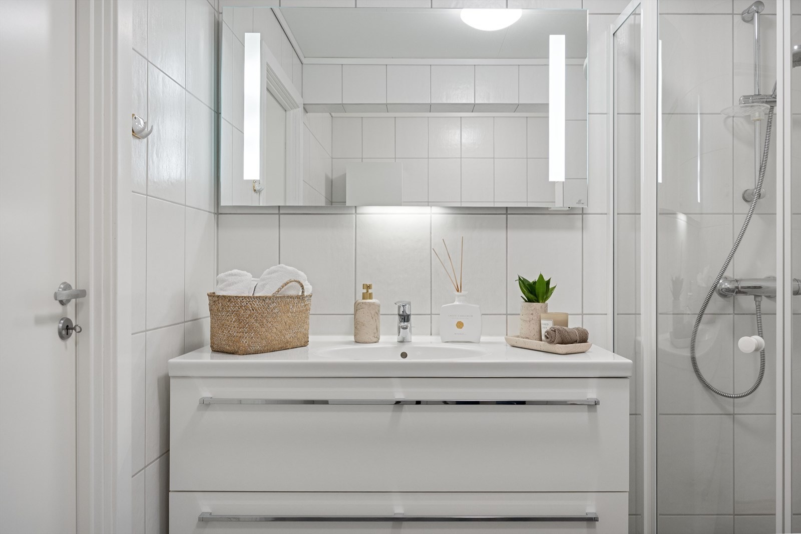 Badet er innredet med pene baderomsmøbler med underbygde skuffer. Speil med innebygde lysfelt Galleribilde