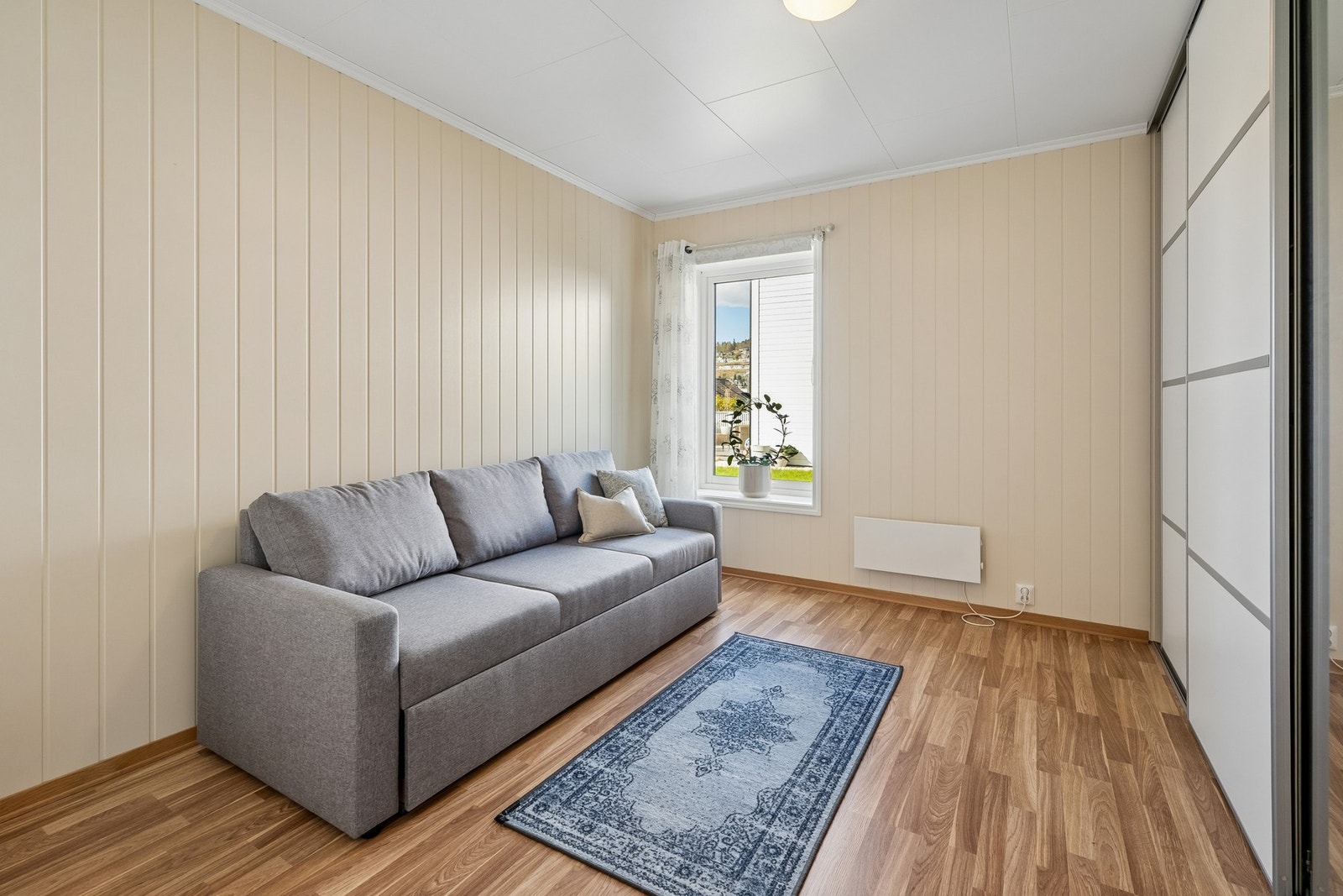 Ein heil vegg med skyvedørsgarderobe gjev god oppbevaringplass og gjer det enkelt å halde orden og system i klede og tilbehøyr Galleribilde
