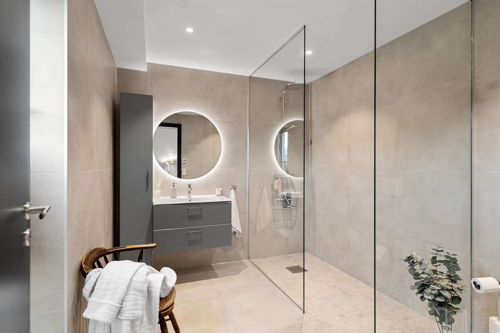 Badet i 1. etasje har fliser på gulv med vannbåren varme. Dusjhjørne er så stort at det er mulighet for badekar. Galleribilde