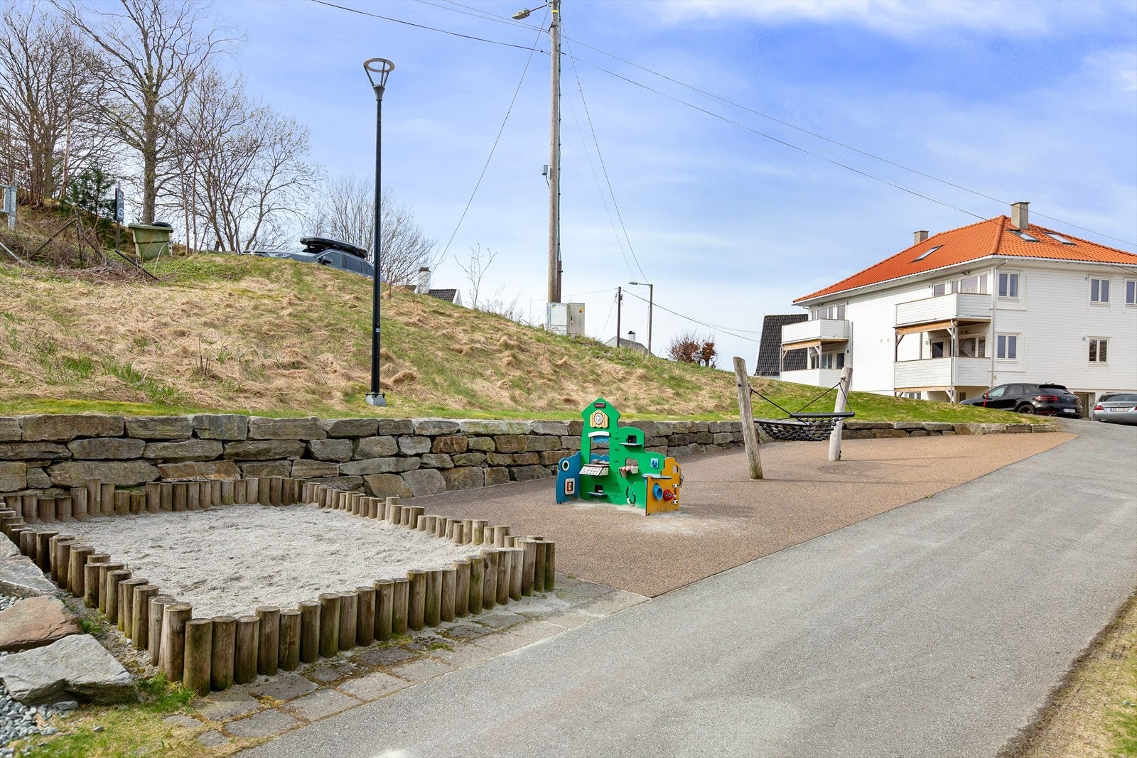 Pent opparbeidet fellestomt med beplanting, grøntareal og asfaltert gårdsrom. Det er opparbeidet med lekeapparater på sørsiden. Galleribilde