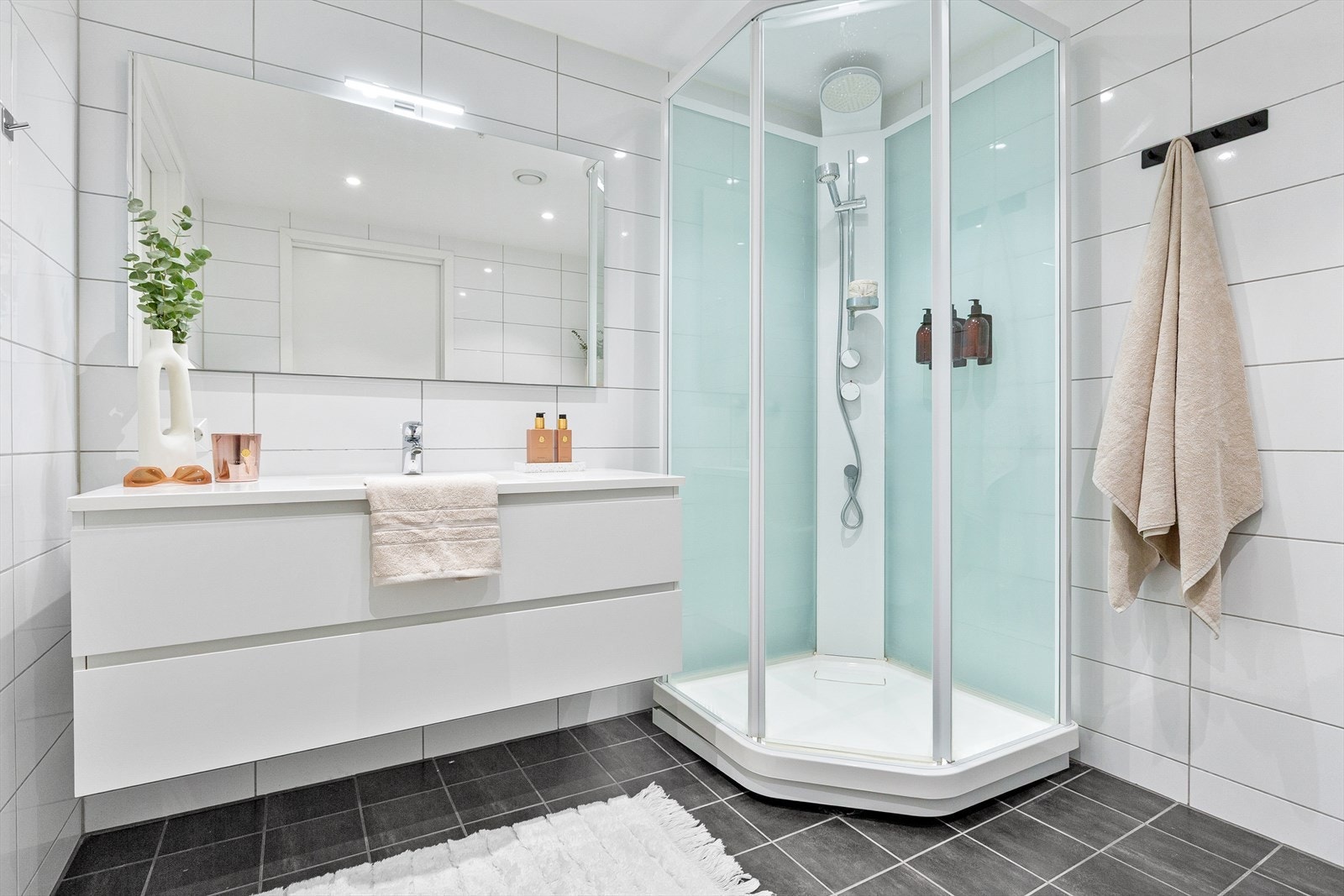 Romslig og fliselagt bad med dusj, servant og wc. Galleribilde