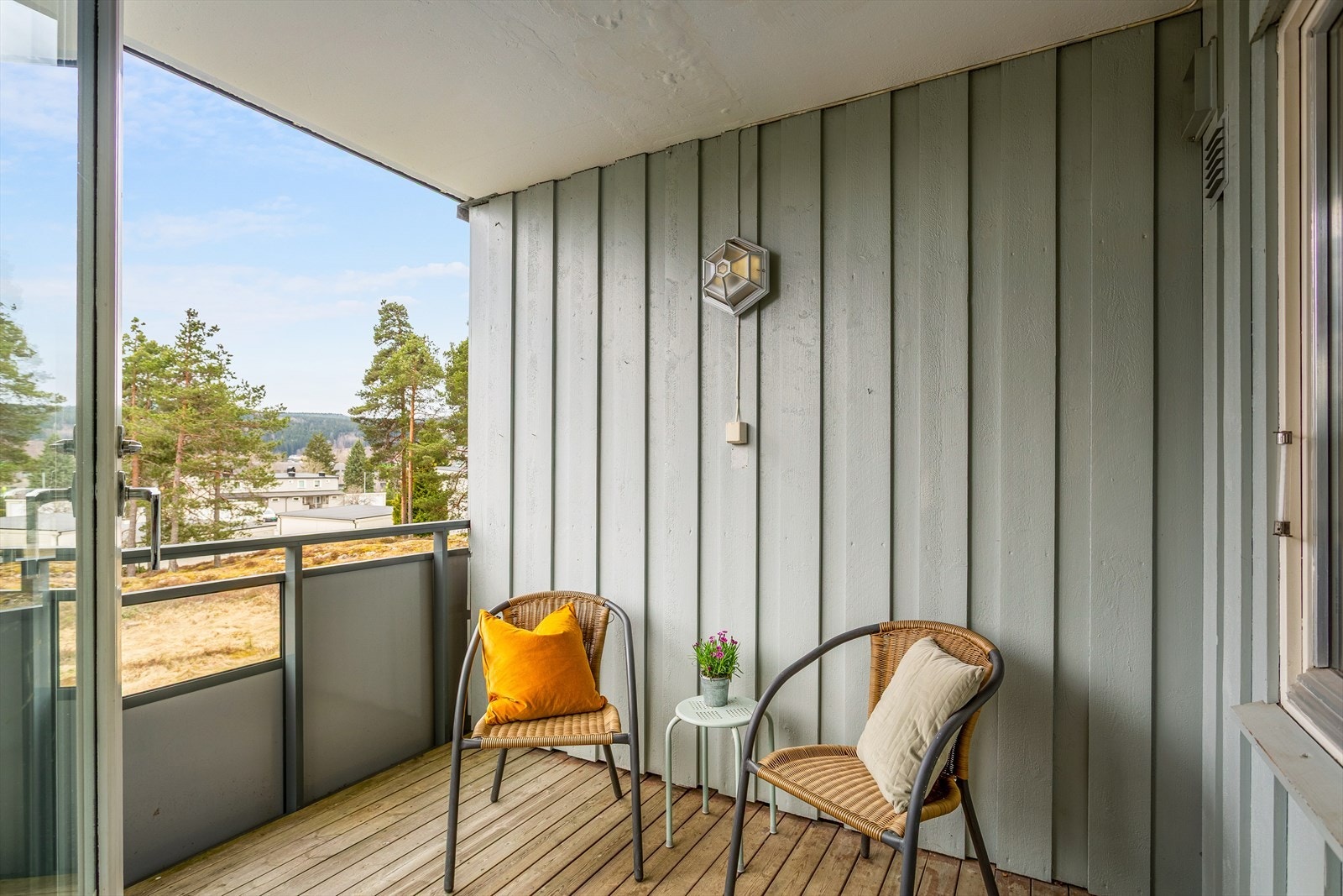 Overbygget og koselig balkong med utsyn mot Tråstad bak furuskogen Galleribilde