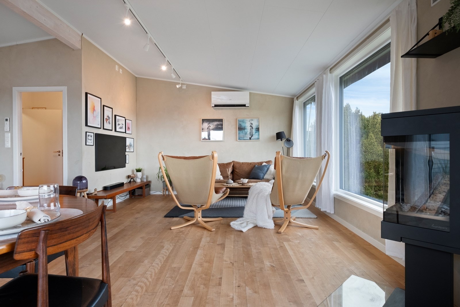 Det er montert både varmepumpe og vedovn på stue Galleribilde