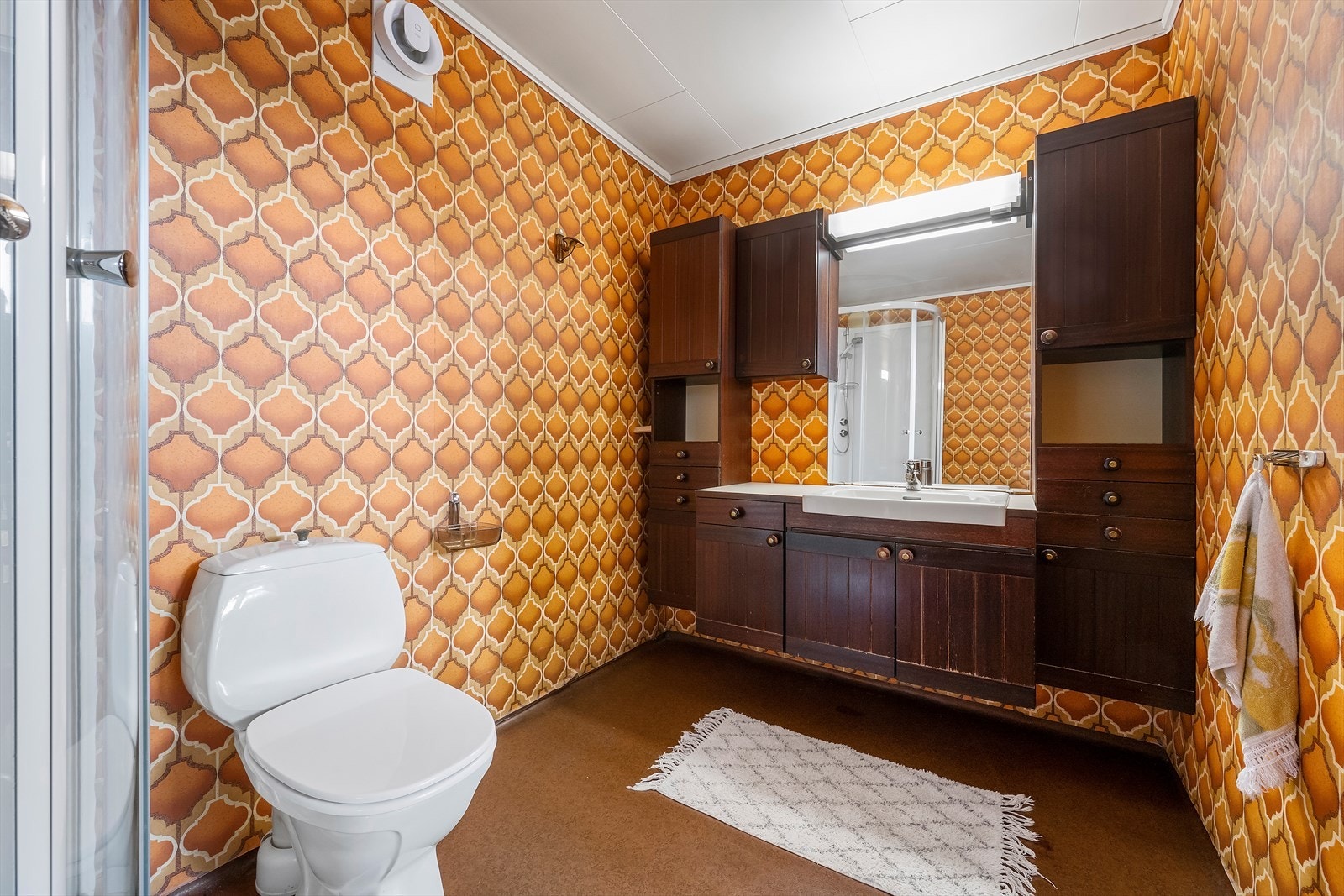 Badet har golv med varmekabel, dusjkabinett og baderomsinnreiing med fleire skap for oppbevaring. Galleribilde