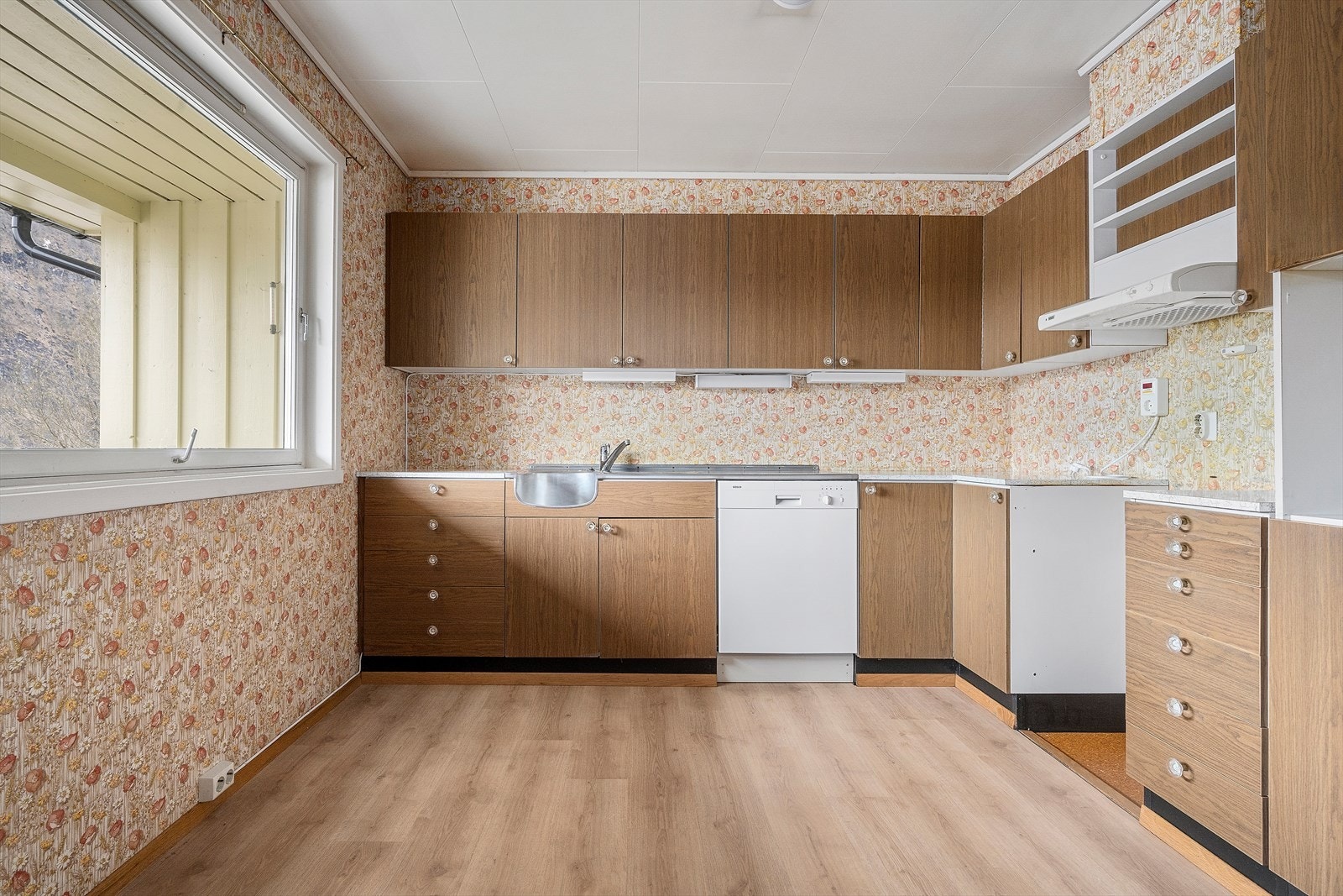Kjøkkenet har innreiing med folierte frontar og laminat benkeplate. Det er opplegg for frittståande kvitevarer. Galleribilde