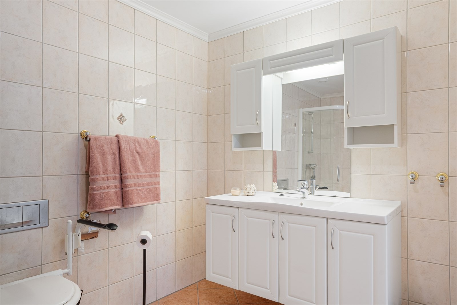 Badet er innredet med dusjhjørne, vegghengt toalett, baderomsinnredning med heldekkende servant og opplegg for badekar. Galleribilde