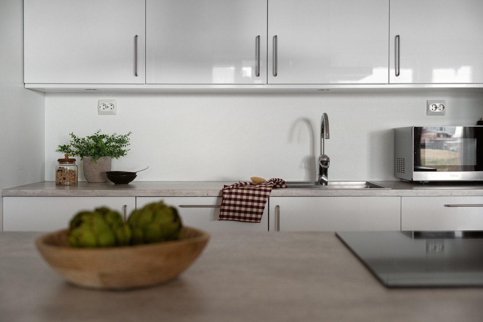 Kjøkkenet har med lyse fronter, laminat benkeplate og nedfelt oppvaskkum i stål