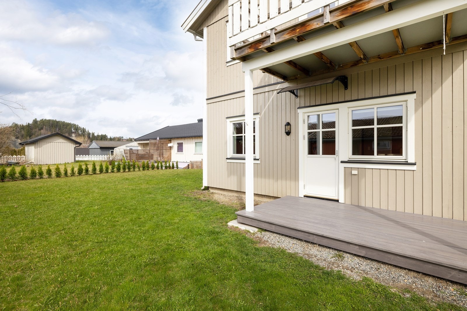 Den overbygde terrasseplattingen utenfor stuen gir en lun og skjermet uteplass. Galleribilde