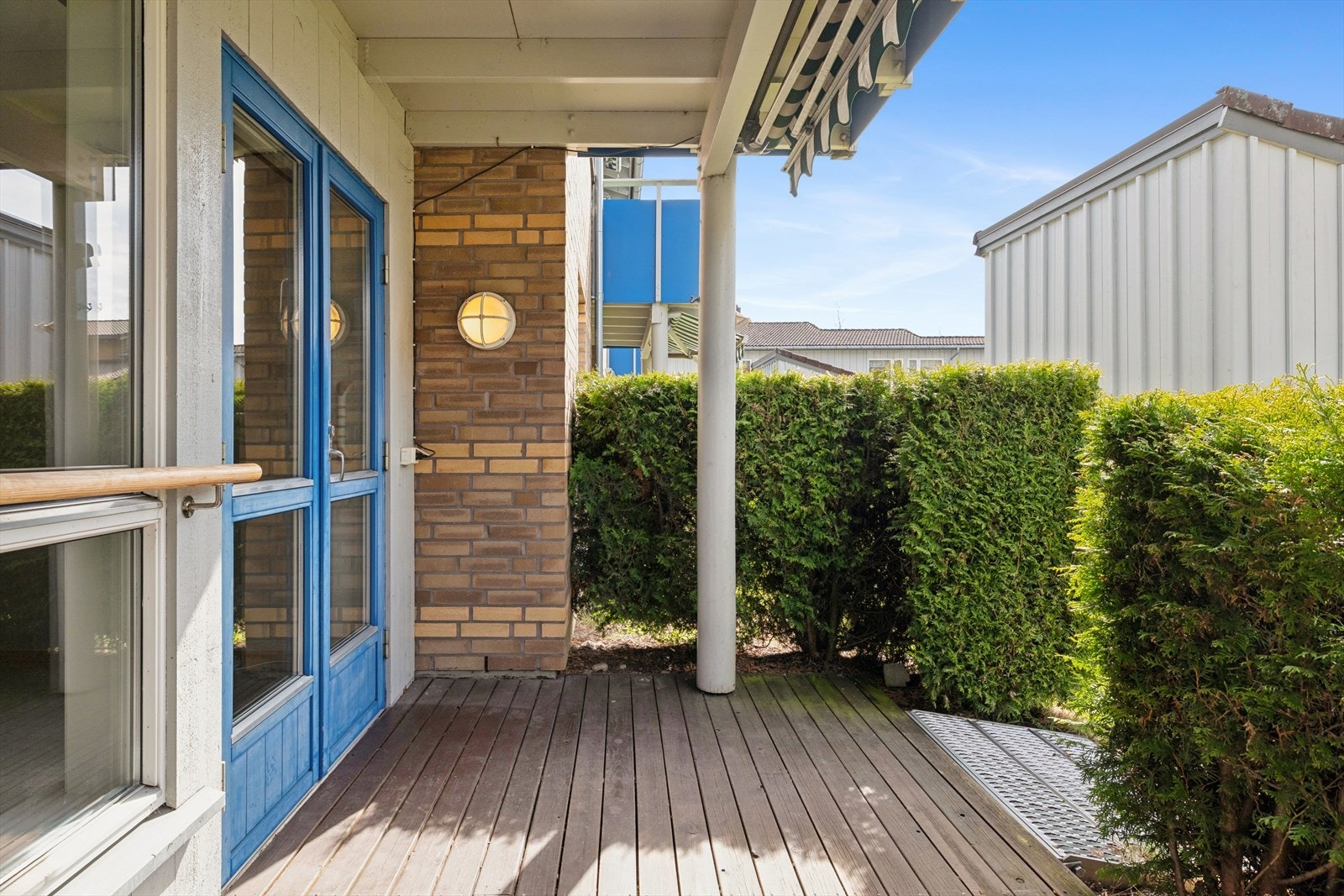 Den overbygde terrasseplattingen på 7 m² er et lunt og privat uterom, skjermet av hekk. Galleribilde