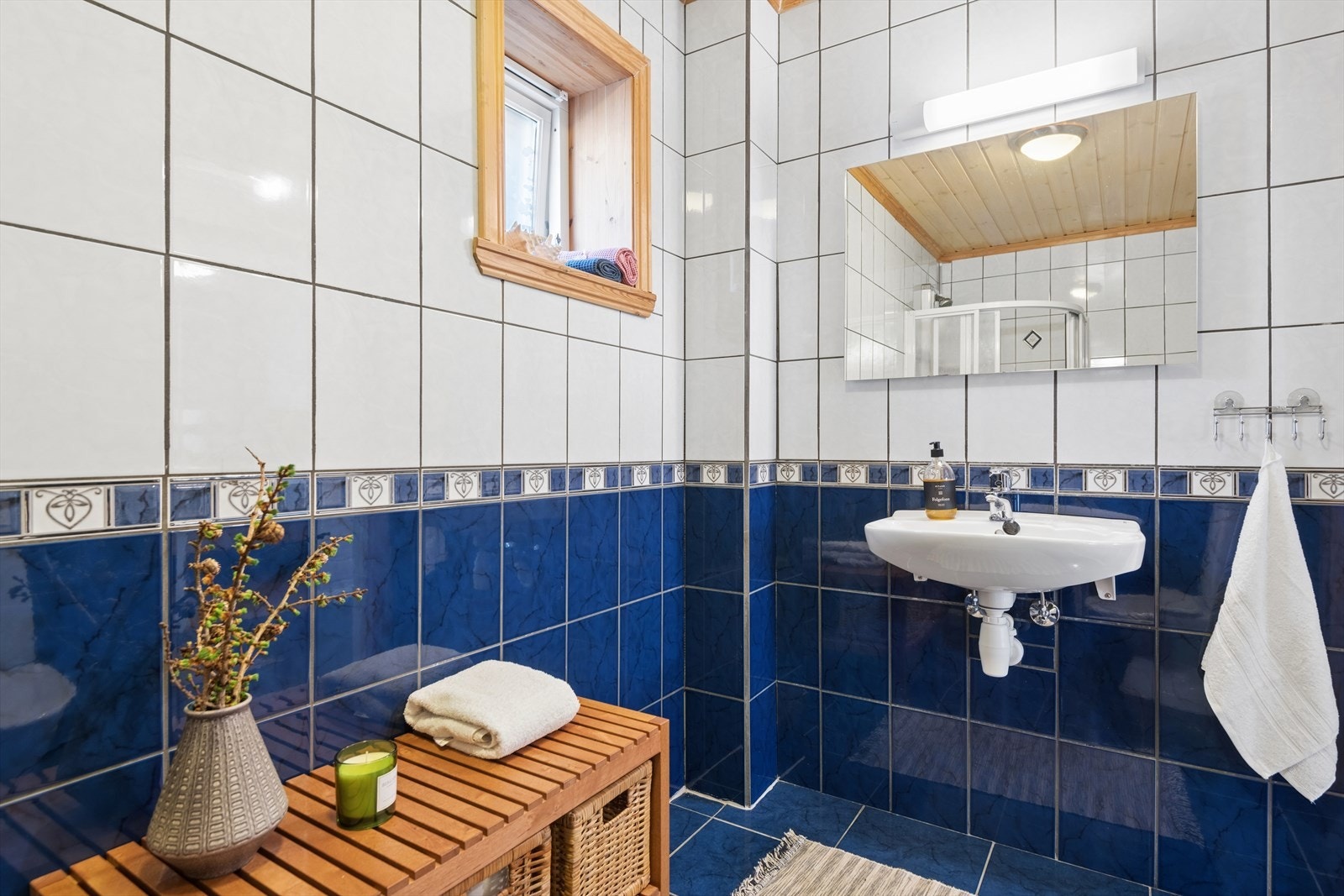 Badet i underetasjen har flislagte overflater på gulv og vegger, og er utstyrt med servant og gulvmontert toalett. Galleribilde