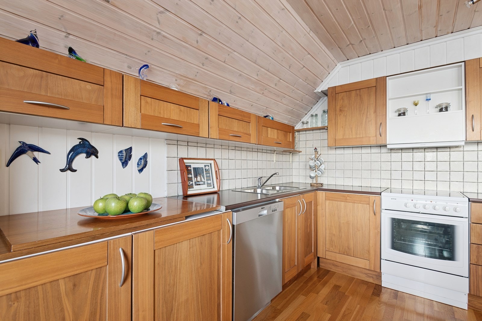 Kjøkkeninnredning fra 2012 med profilerte fronter og laminert benkeplate. Kjøkkenet er utstyrt med frittstående hvitevarer samt ventilator med avtrekk direkte ut. Galleribilde