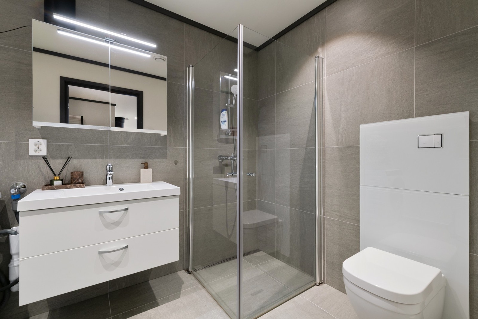 Badet er innredet med toalett, servant, dusj og opplegg for vaskemaskin. Galleribilde