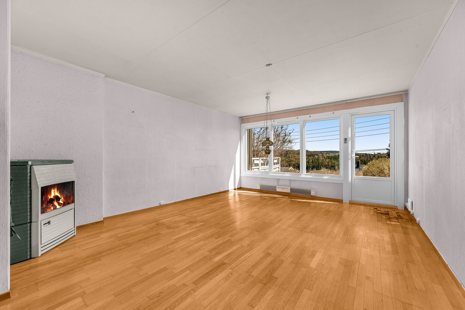 Stuen fremstår som romslig og luftig med store vindusflater som slipper inn rikelig med naturlig lys. Galleribilde