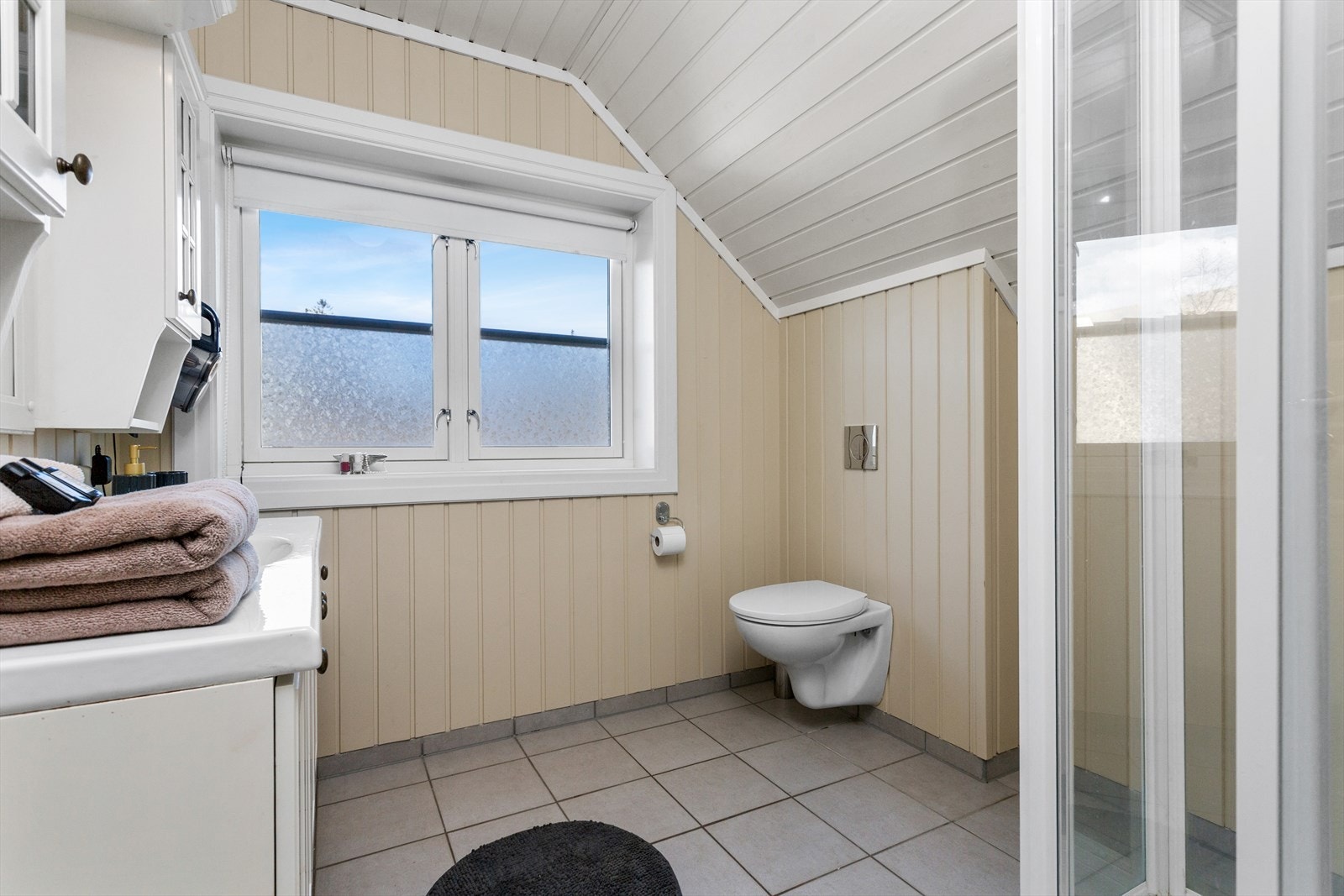 Badet i 2. etasje har flislagt gulv med undervarme, malte panelvegger og malt panelhimling Galleribilde