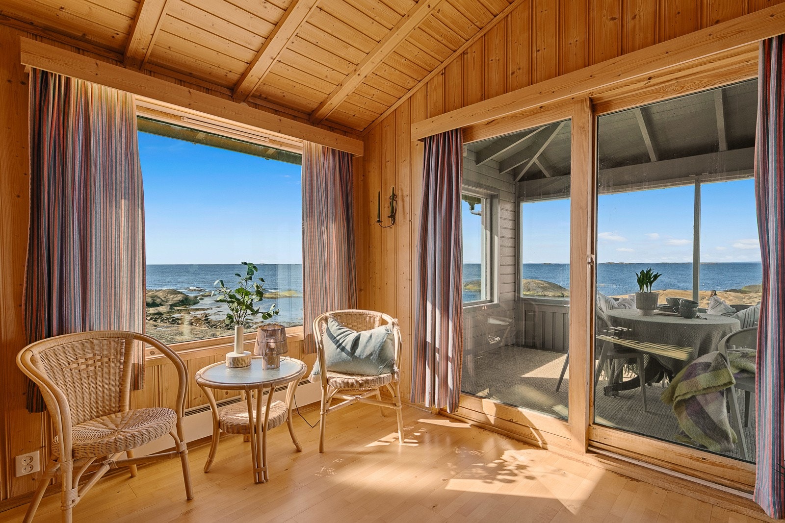 Fra stua er det utgang til en herlig takoverbygget terrasse som blir som en forlengelse av stua. Her kan du nyte nærheten til sjøen dagen lang - enten det er tidlige morgener med kaffe og bølgeskvulp, eller lange sommerkvelder med utsikt mot horisonten. Galleribilde