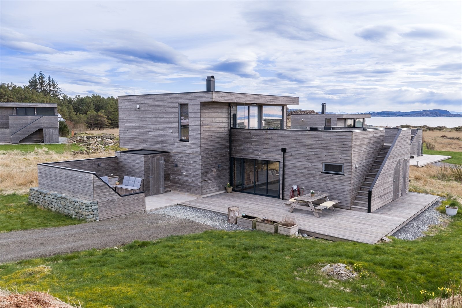Stor tomt, hvor en har en stor gruslagt parkering, solrike og skjermede terrasser med fri utsikt. Galleribilde