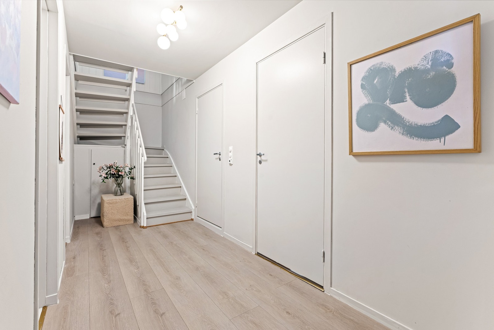 Inngangsparti med trapp opp til andre etasje og flere dører til ulike rom. Galleribilde
