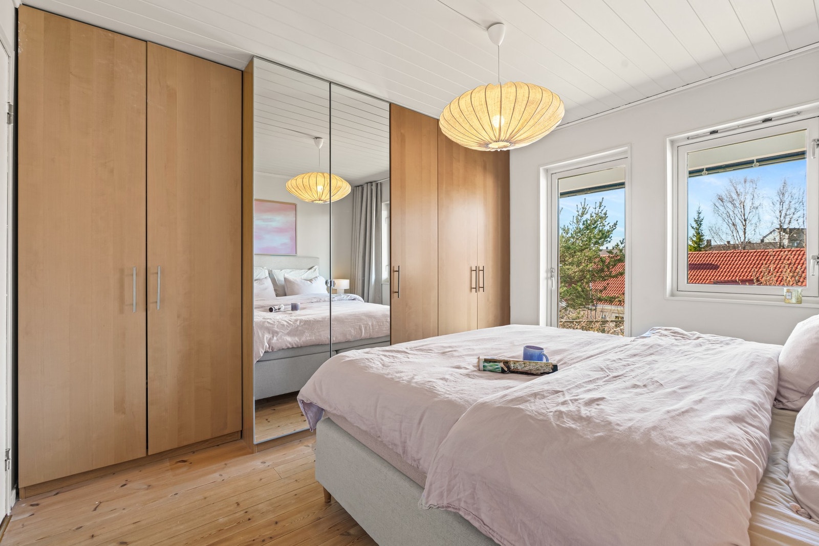 Soverom med store vinduer, innebygde garderobeskap og naturlig lysinnslipp. Galleribilde