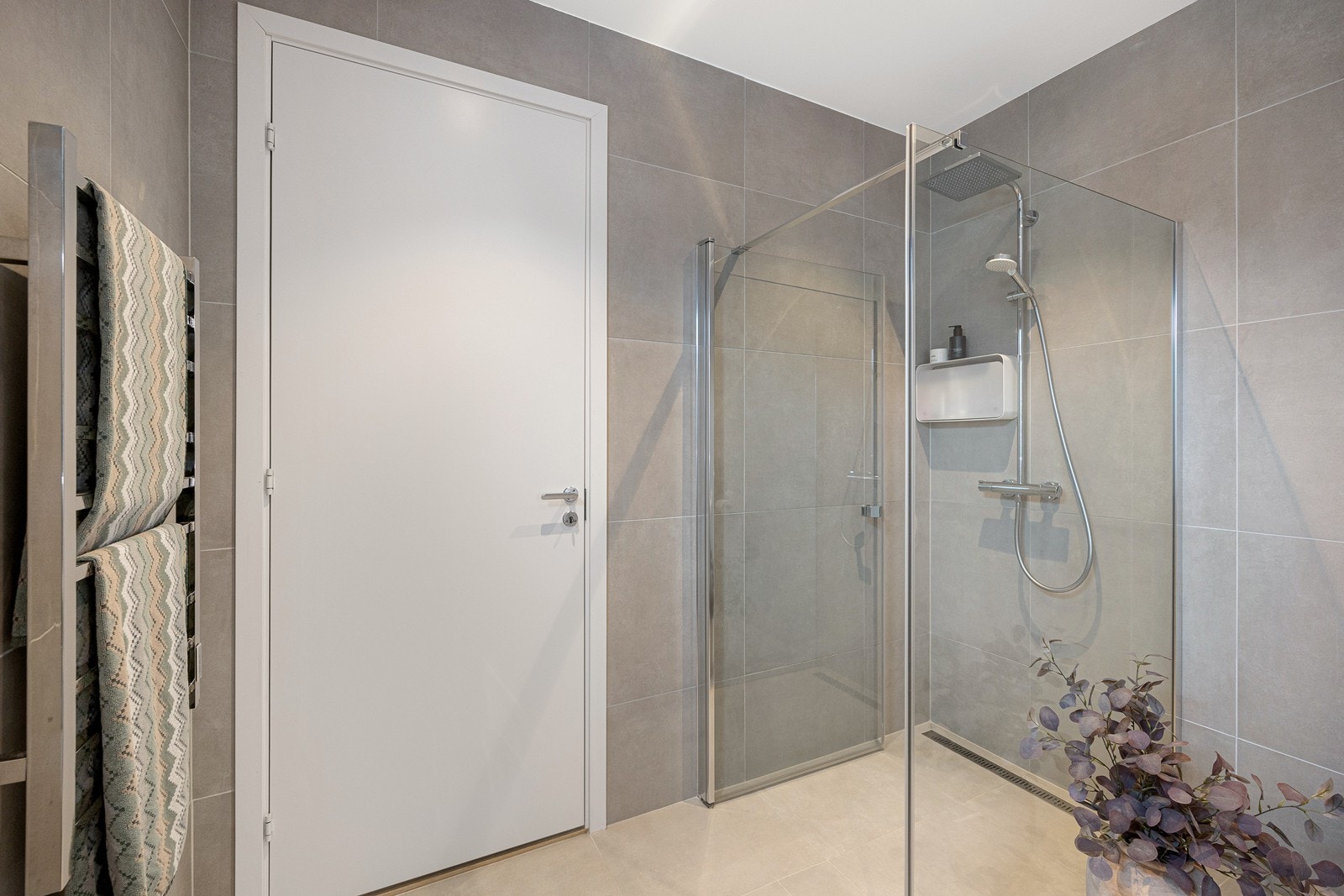 Badet er utstyrt med regnfallsdusj, elektrisk håndkletørker, vegghengt toalett og servantinnrending. Galleribilde
