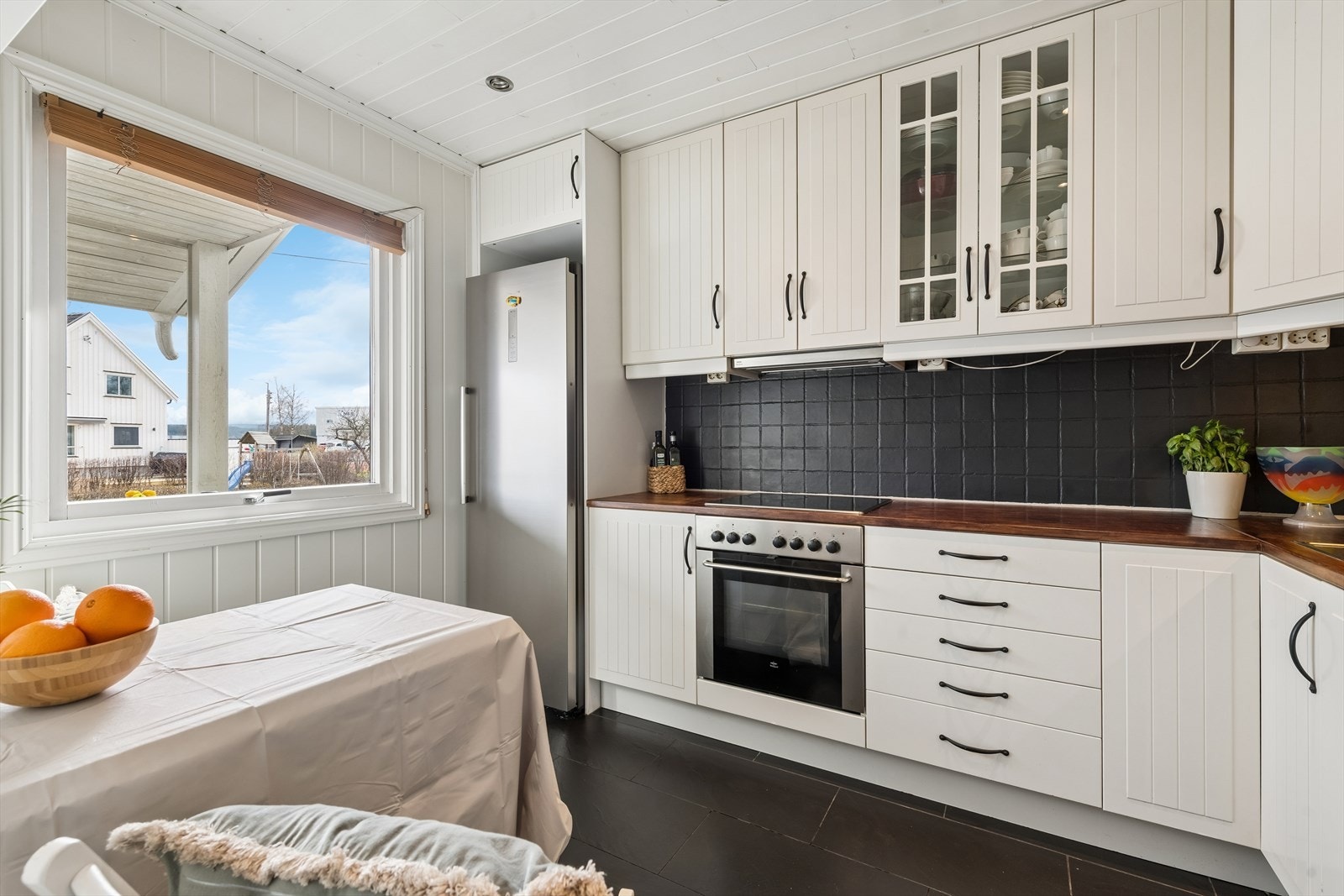 Kjøkkeninnredning med profilerte fronter og benkeplate i heltre. Her er det også plass til en koselig spiseplass. Galleribilde