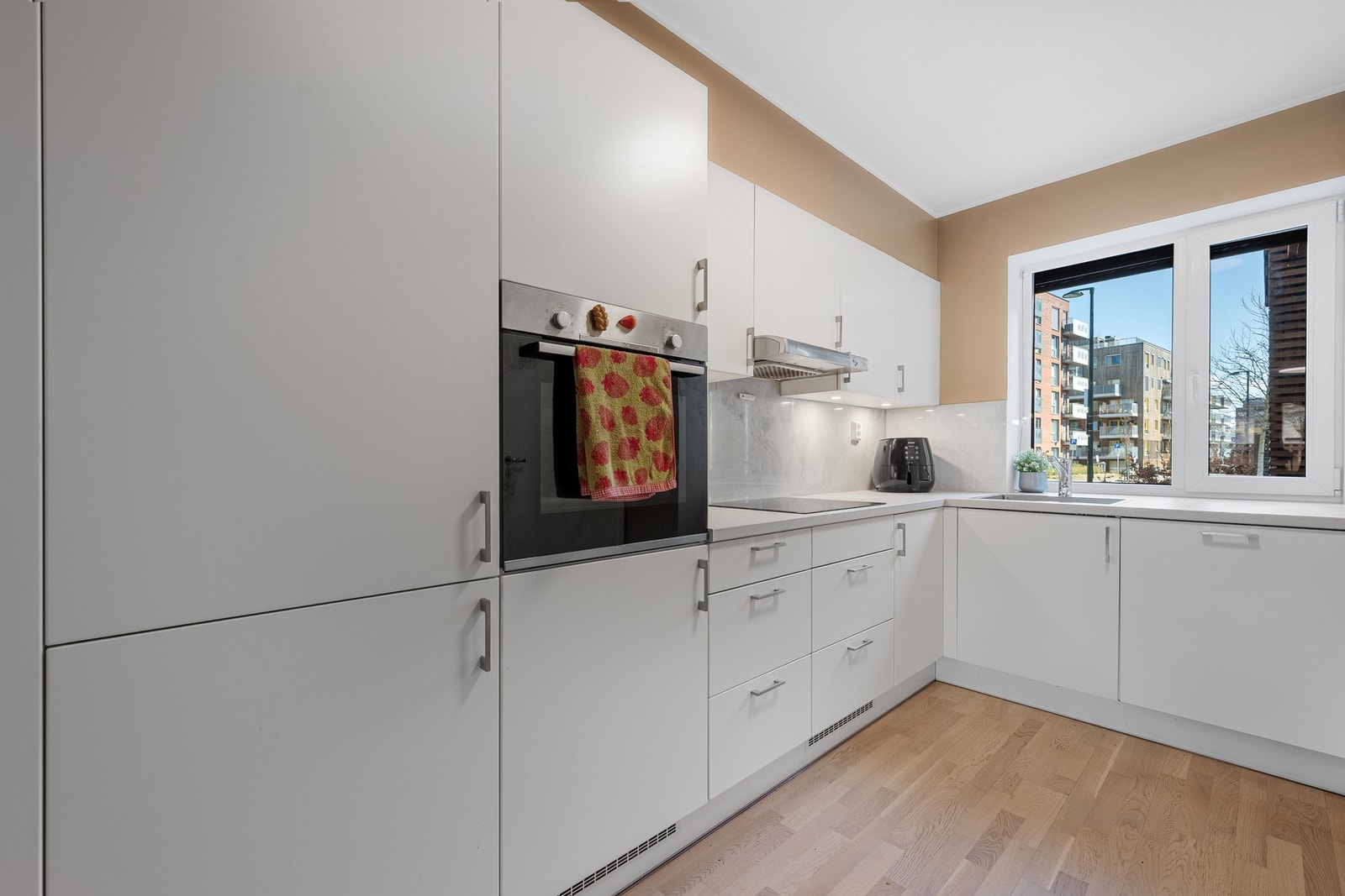 Kjøkkenet har en tidløs innredning med glatte fronter og benkeplate av laminat. Galleribilde