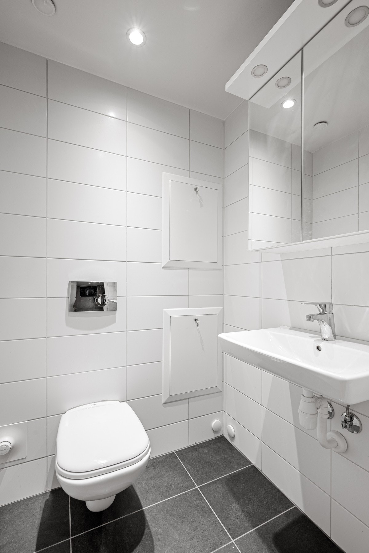 Pent separat WC med enkel adkomst fra 1. etasje. Rommet har flislagte vegger og gulv, og er innredet med servant med speilskap samt vegghengt toalett. Galleribilde