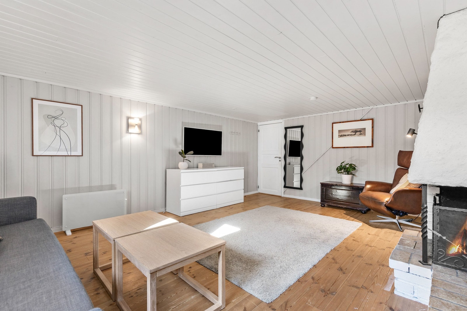 Kjellerstuen med åpen peis. Rommet er ikke godkjent for varig opphold. Galleribilde