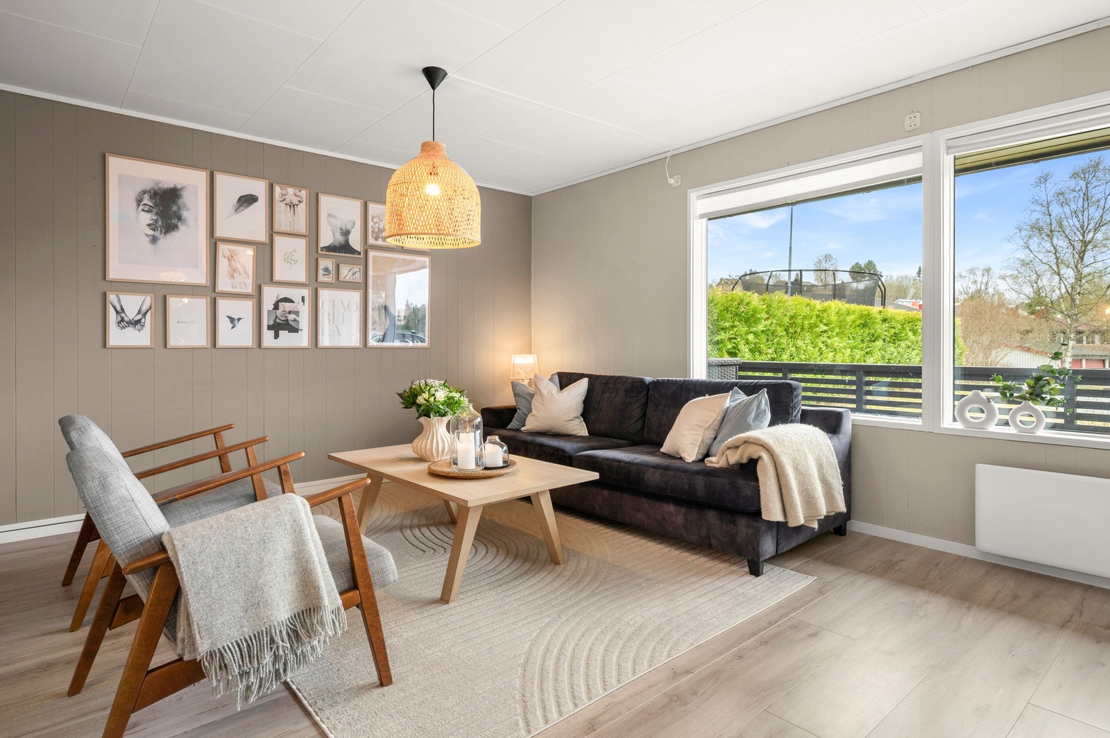 Store vindusflater og doble verandadører gir godt med naturlig lys inn i stua. Galleribilde
