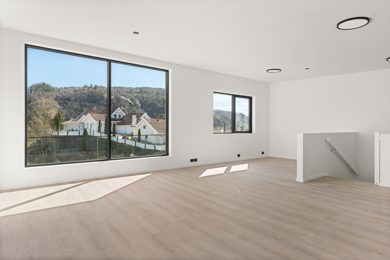 Her er åpen løsning mellom stue og kjøkken og store vindusflater som slipper inn godt med lys Galleribilde