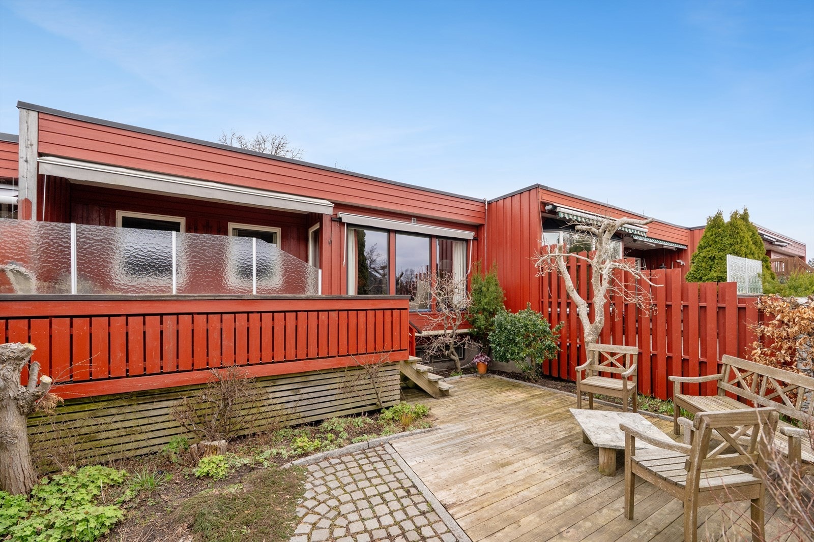 Fra verandaen er det trapp ned til en skjermet og dels steinsatt uteplass på bakkeplan. Galleribilde