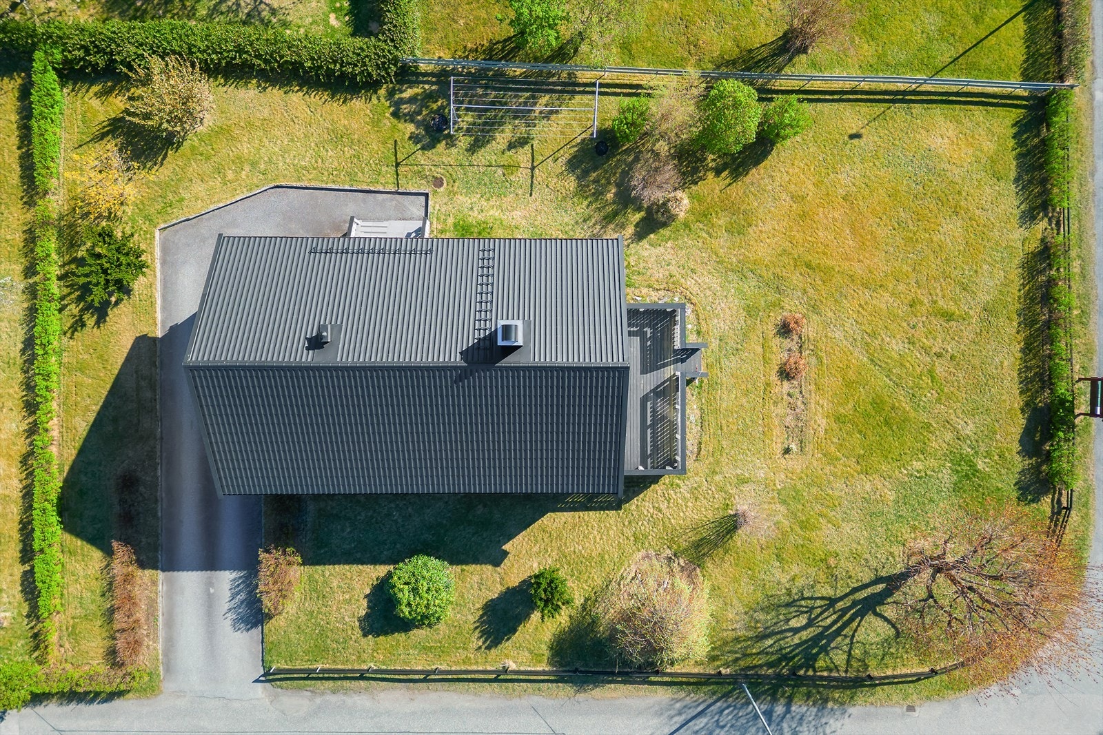 Eiendommen har en romslig tomt med plen og innramming av hekk. Galleribilde