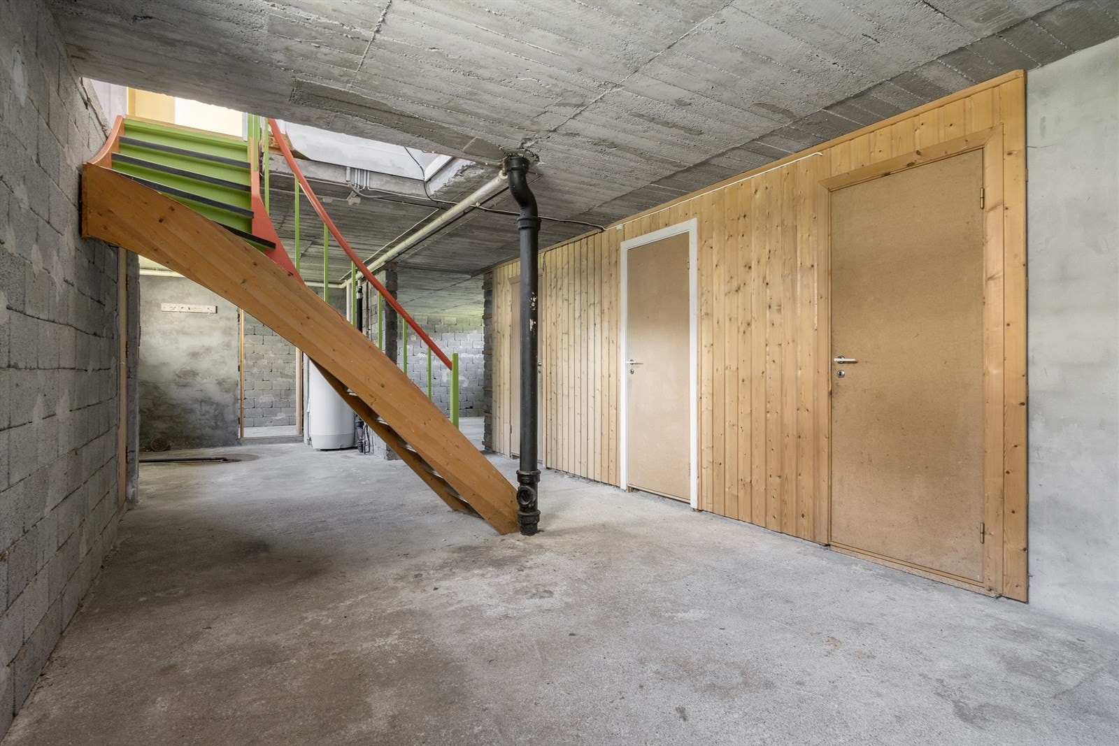 Rommet har støpte gulv og murvegger og dører til forskjellige boder. Galleribilde
