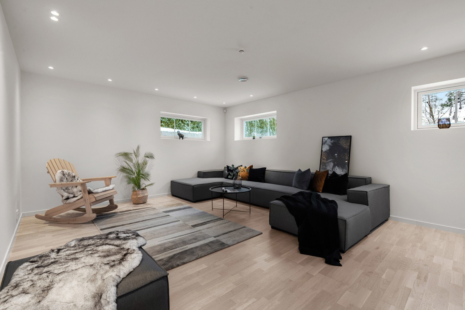 Kjellerstuen oppleves lys og luftig med flere vindusflater kombinert med downlights i himling og 3-stavs parkettgulv Galleribilde