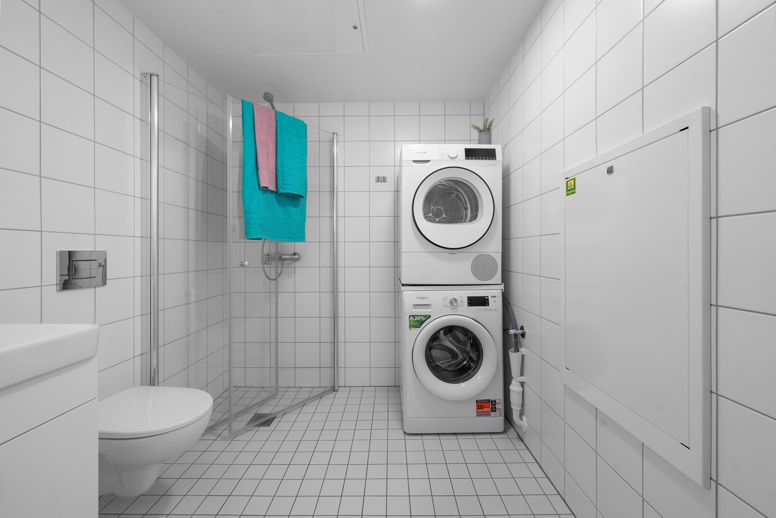 Badet er helfliset og har elektrisk gulvvarme, vegghengt toalett og opplegg for vaskesøyle. Galleribilde