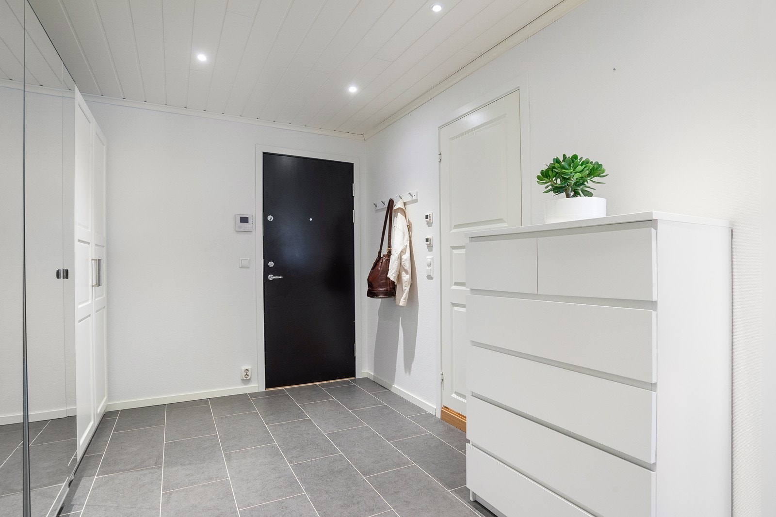 Entreen er stor og skaper et godt førsteinntrykk med pene overflater. Flislagt gulv med elektriske varmekabler og downlights i himling Galleribilde