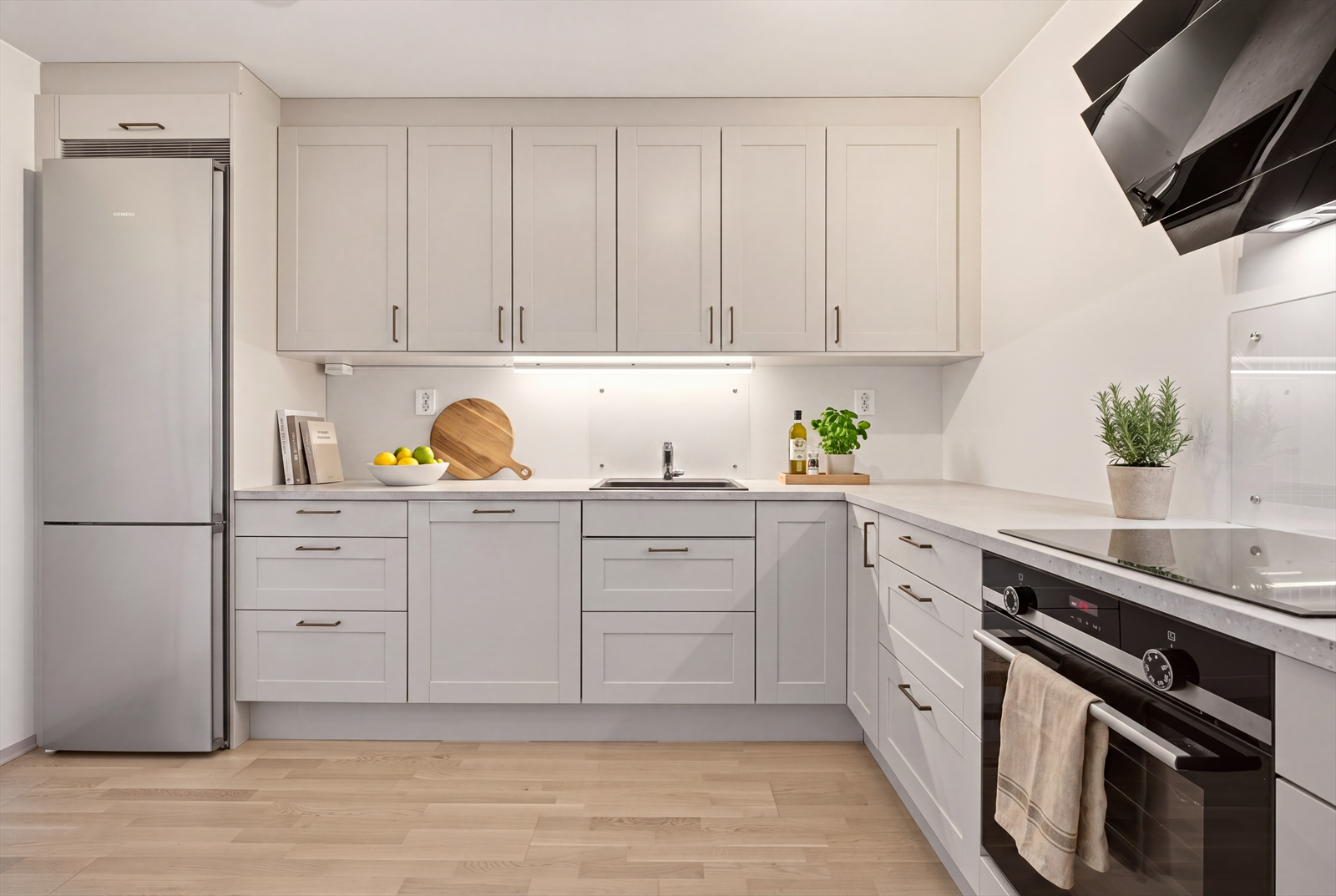 Leiligheten har et pent og moderne kjøkken fra Norema med profilerte fronter og benkeplate av laminat (Digital styling) Galleribilde