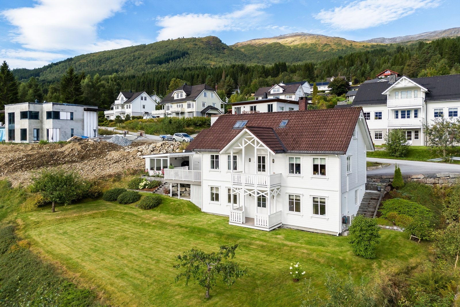 Pent opparbeidet hage med plen, beplantning og trapper som binder de ulike nivåene sammen på en god måte. Galleribilde
