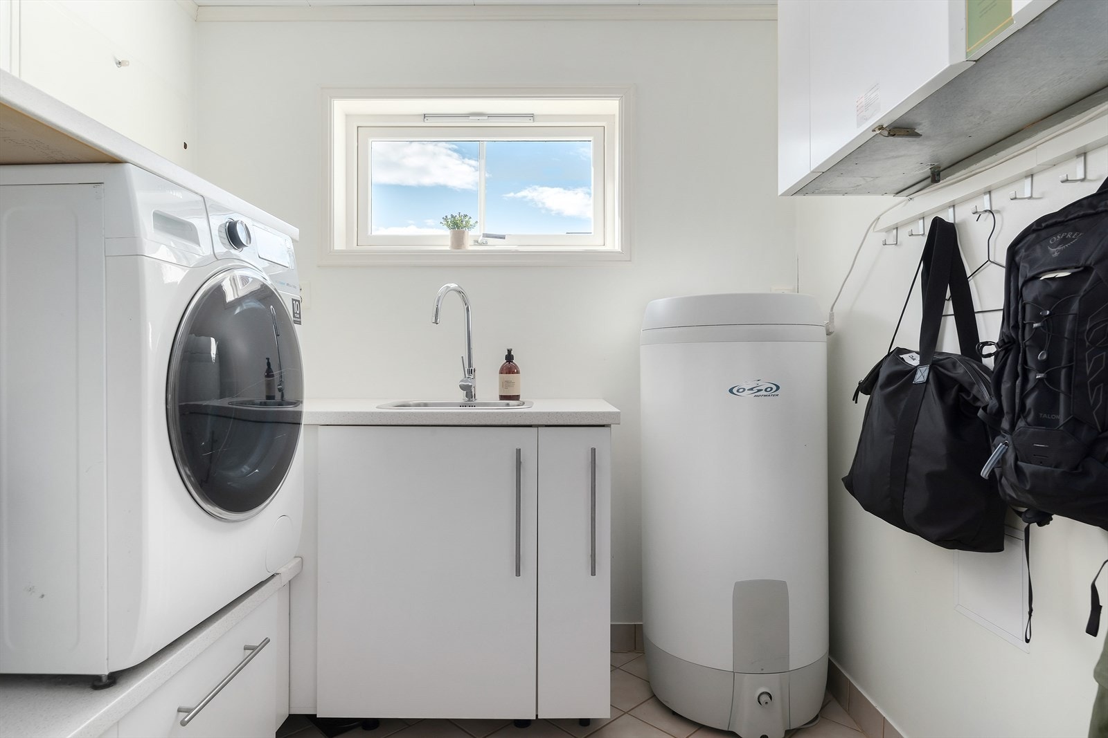 Vaskerom med praktisk innredning med utslagsvask. Her er opplegg for vaskemaskin og tørketrommel. Samt at ventilasjonsanlegg og varmtvannstank er plassert her. Galleribilde