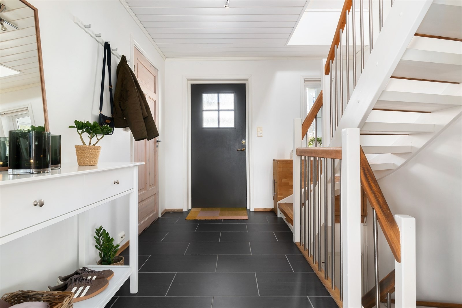 Velkommen inn. Hallen har god plass til å henge fra seg yttertøyet. Praktisk med fliser og varmekabler. Galleribilde