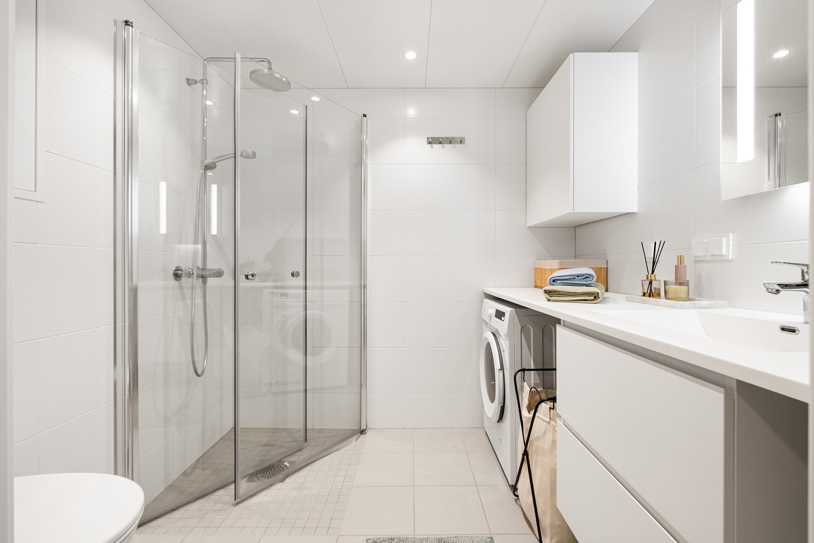 Leilighetens bad, i likhet med resten av leiligheten, fremstår lyst og innbydende. Pene fliser på vegger og gulv. Badet holdes varmt året rundt ved bruk av varme i gulv. Galleribilde