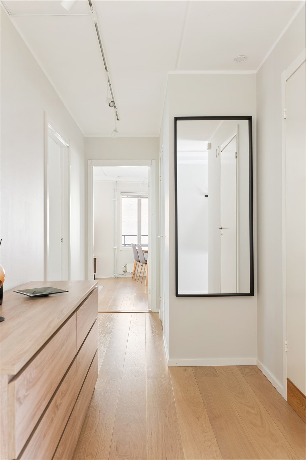 Leiligheten har en arealeffektiv planløsning som skiller soverommene fra den sosiale sonen. Hjørneplasseringen gir en ekstra romslig og innbydende atmosfære. Galleribilde