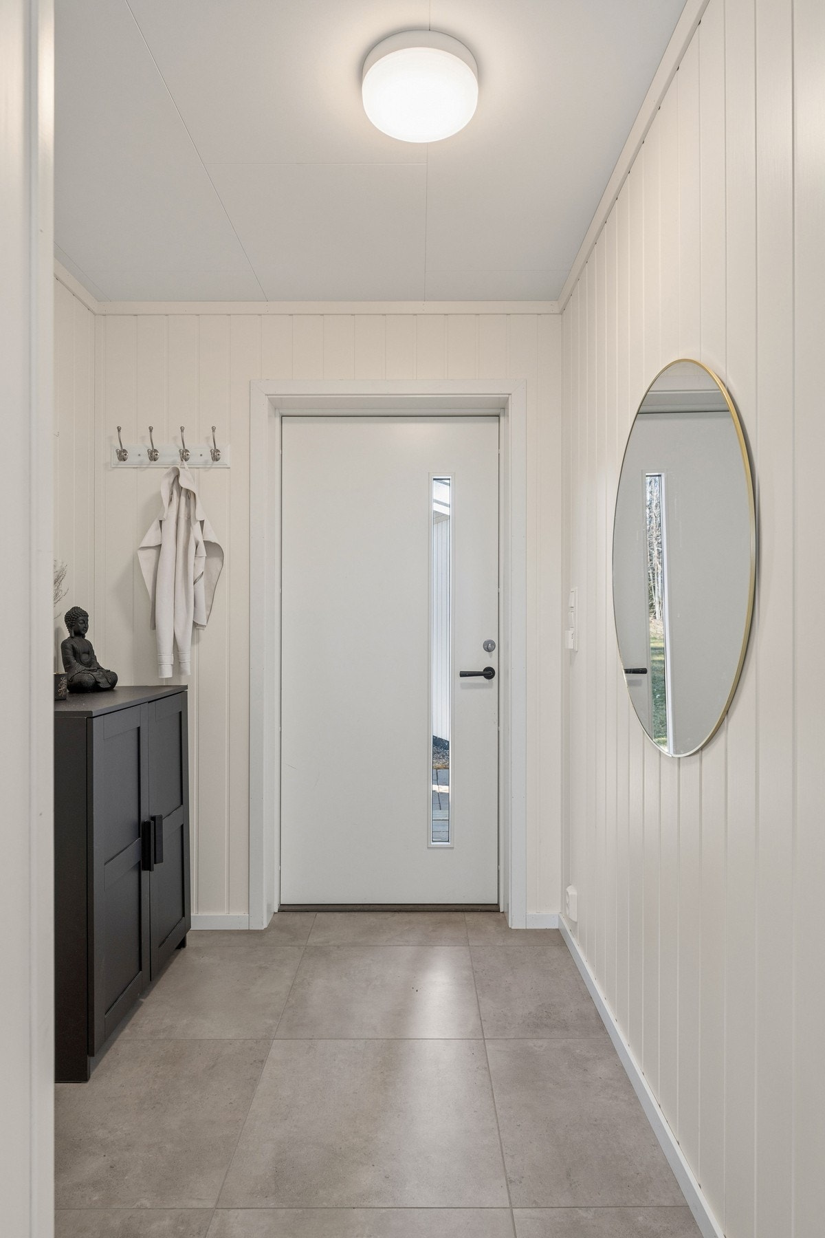 Her kommer du inn i en flislagt entrè med gulvvarme og plass til sko og yttertøy. Galleribilde