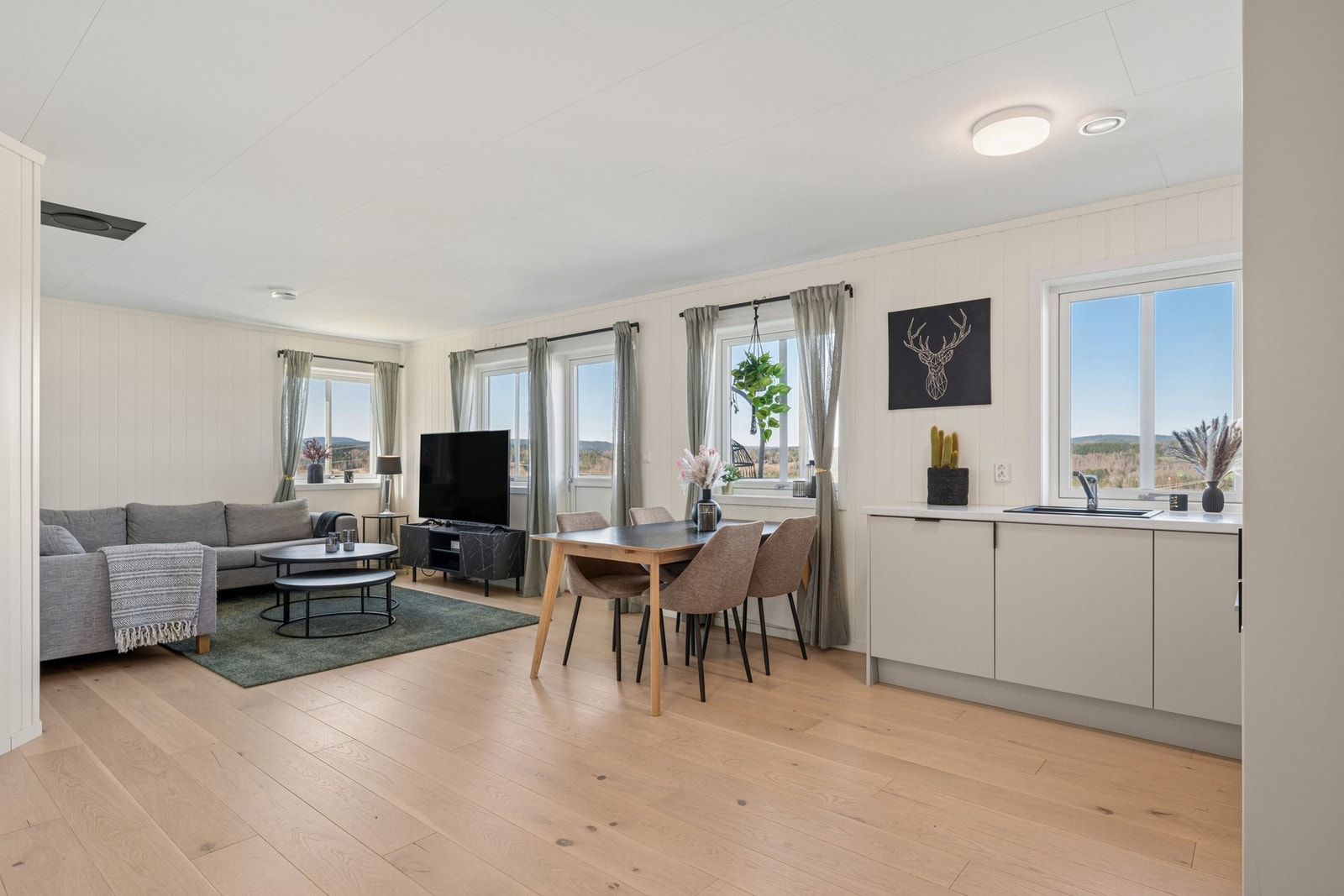 Stuen fremstår som lys og romslig, med god plass til både sofagruppe, spisebord og øvrig ønsket møblement. Galleribilde