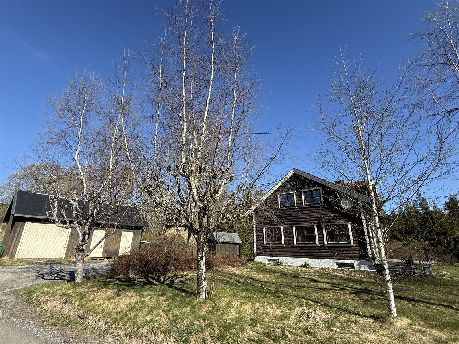 På inngangssiden har huset en gruslagt gårdsplass med mulighet for parkering. Gårdsplassen binder boligen sammen med et frittstående uthus. Galleribilde