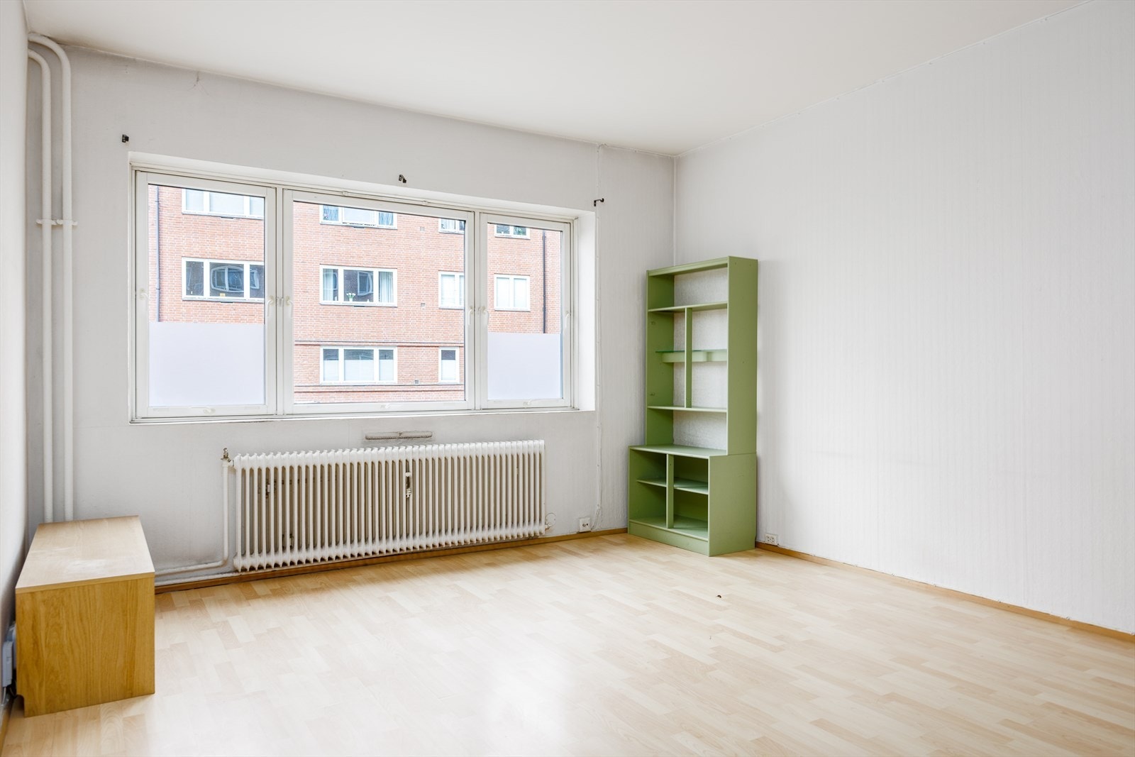 Stue har godt dagslys og utsyn mot gårdsrommet Galleribilde