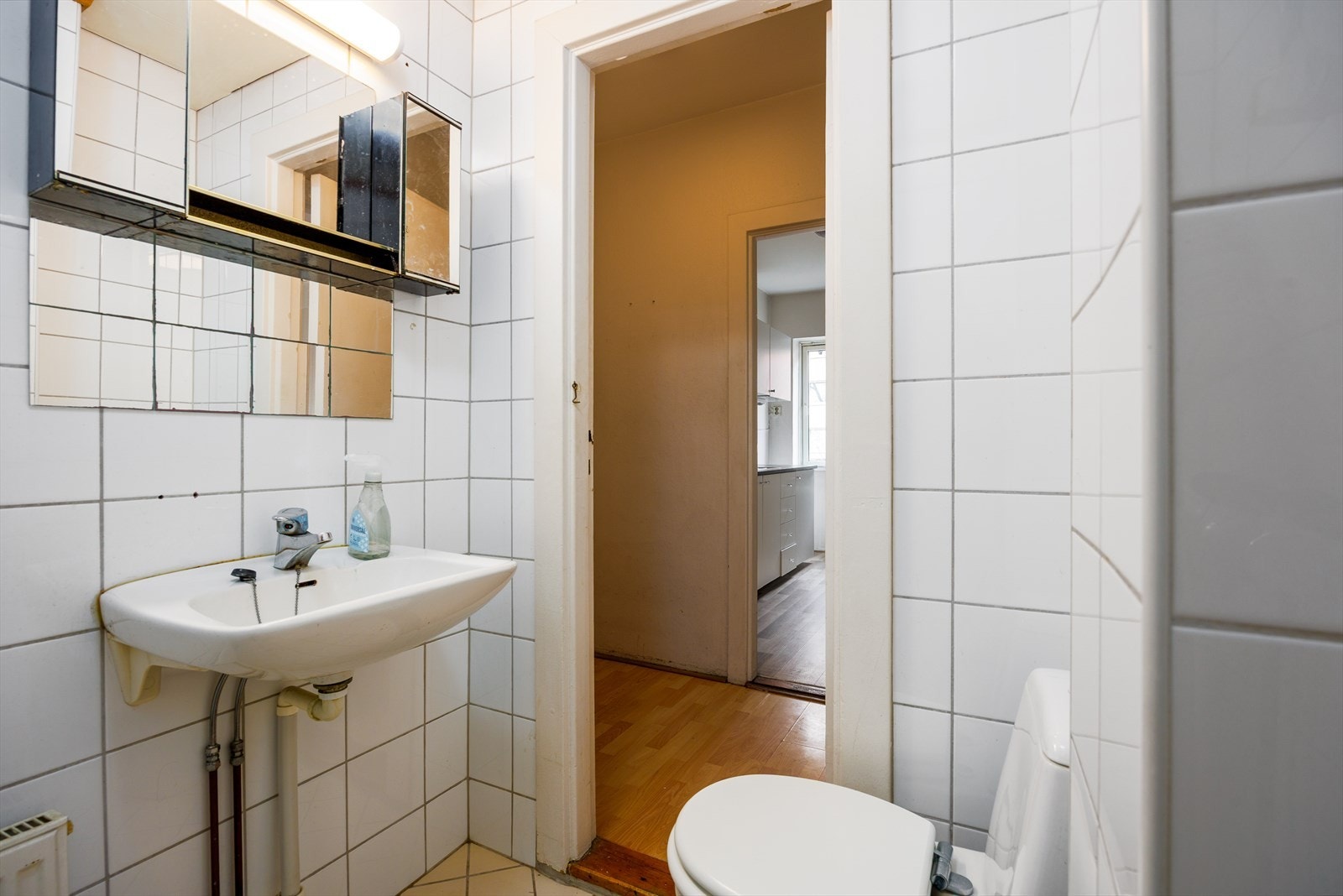 Badet har servantseksjon med speil og flislagte vegger Galleribilde