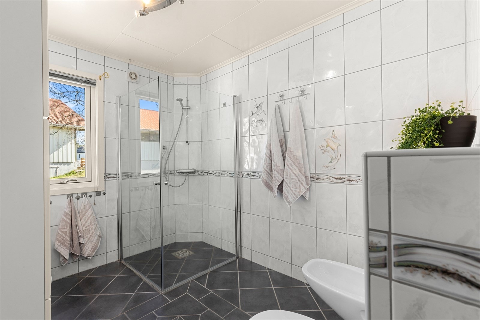 Badet er utstyrt med hjørnedusj, toalett, bidet, samt baderomsinnredning med rikelig oppbevaringsplass. Galleribilde