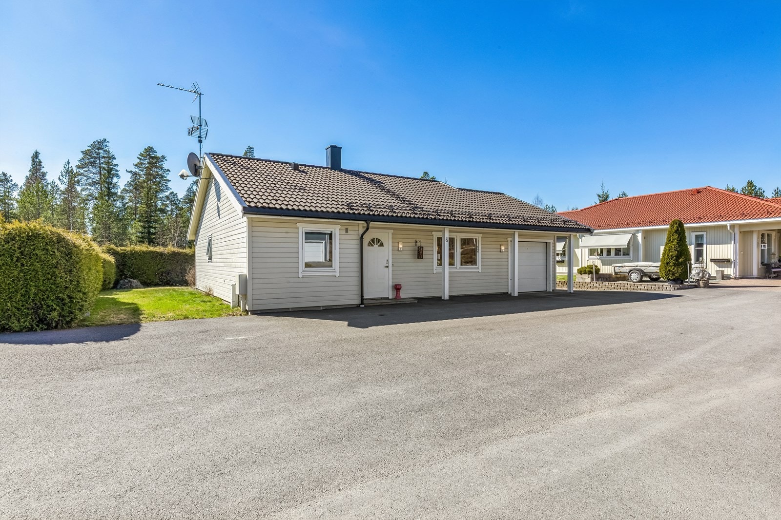 Integrert garasje med motorisert leddport og en isolert bod i bakkant. Asfaltert gårdsplass gir rikelig med biloppstillingsplass. Galleribilde